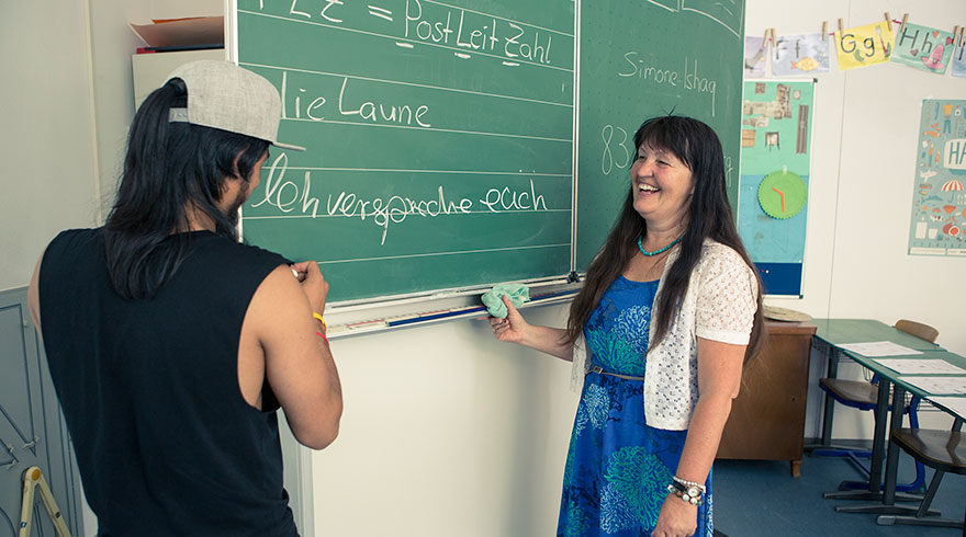 Dans la salle de classe : Marianne Penn devant le tableau avec un élève.